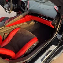 Red and black sports car seat and center console after cleaning